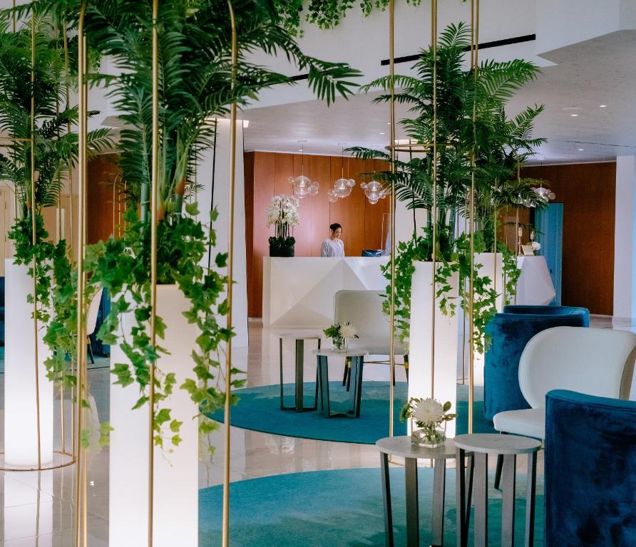 a lobby with potted plants on the walls at Ivi Mare - Designed for Adults by Louis Hotels in Paphos