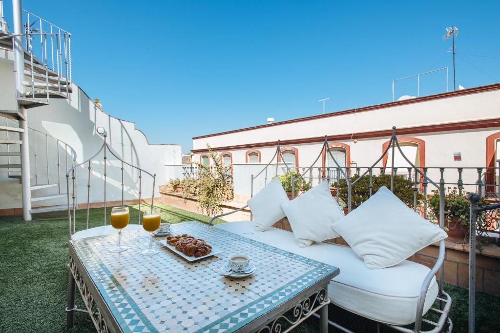 een patio met een tafel en een bank op een balkon bij Maestranza Boutique in Sevilla