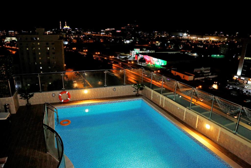a swimming pool on the roof of a building at night at The Palace Hotel - فندق القصر in Muscat