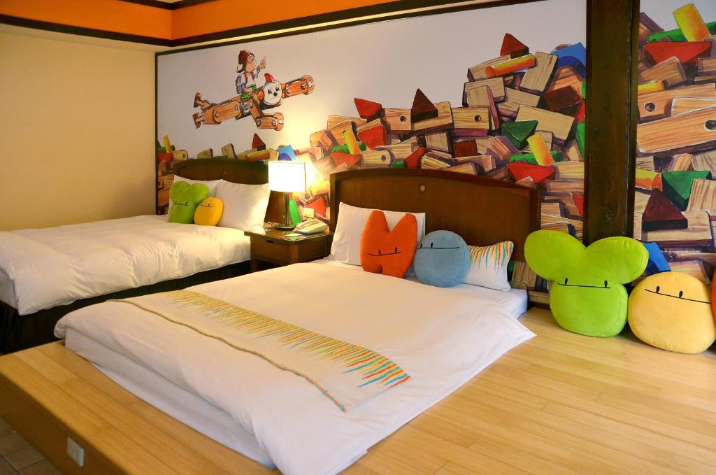 a bedroom with two beds and a pile of books on the wall at Yoho Beach Resort Kenting in Hengchun
