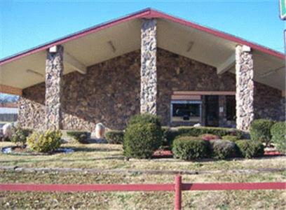 un edificio con una valla roja delante de él en Post Oak Inn, en Brownwood