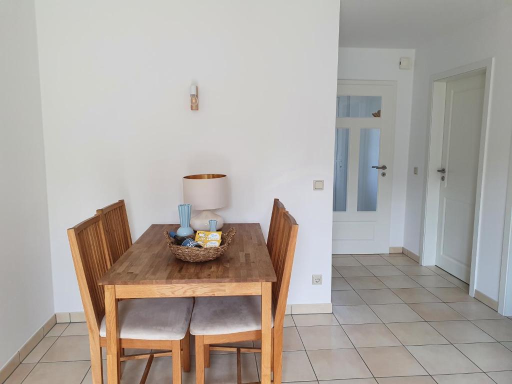 een eettafel met stoelen en een kom eten erop bij Ferienwohnung Amselring in Heringsdorf