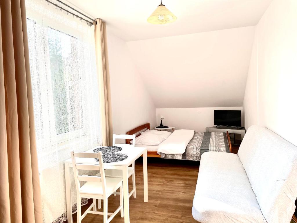 博赫尼亞的住宿－Gościniec i Restauracja Salton，一间卧室配有一张床、一张桌子和一张沙发