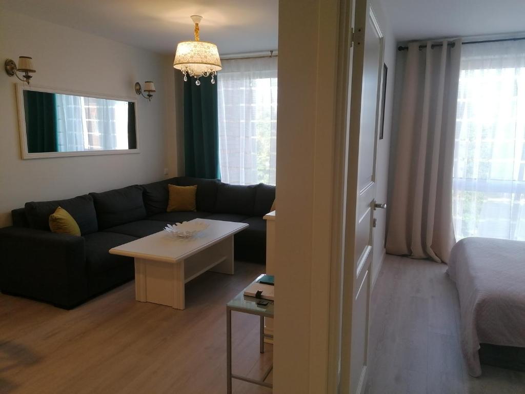 - un salon avec un canapé et une table dans l'établissement Romos apartamentai Klaipėdoje, à Klaipėda