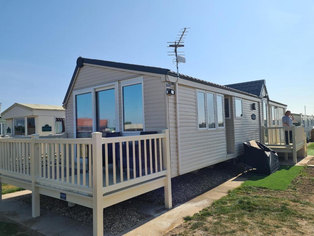 a tiny house with a porch and a fence at 6 Berth The Chase Ingoldmells Concept in Ingoldmells