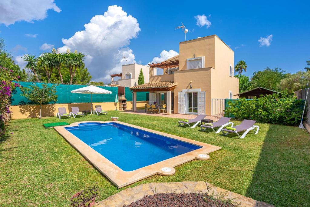 een achtertuin met een zwembad en een huis bij Son Ganxo ii in Cala Murada