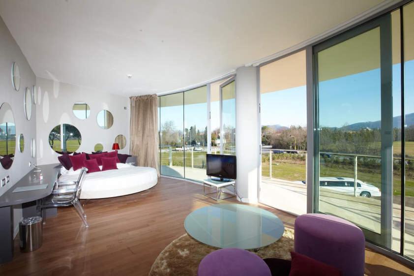 a living room with a couch and a large window at Pisa Tower Plaza in Pisa