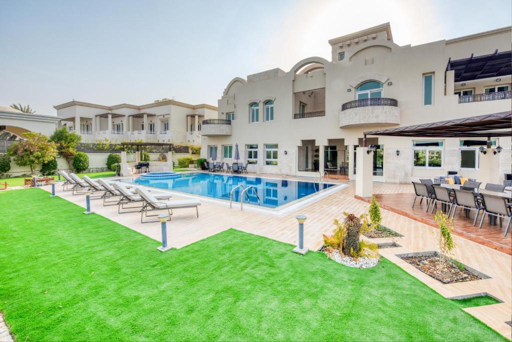 ドバイにあるUltra Luxurious 9BR Villa in Emirates Hills by Deluxe Holiday Homesのスイミングプール付きの家像