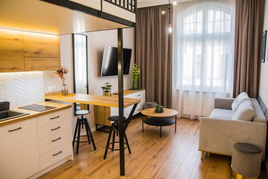 a kitchen and living room with a table and a couch at Piernikowe in Toruń