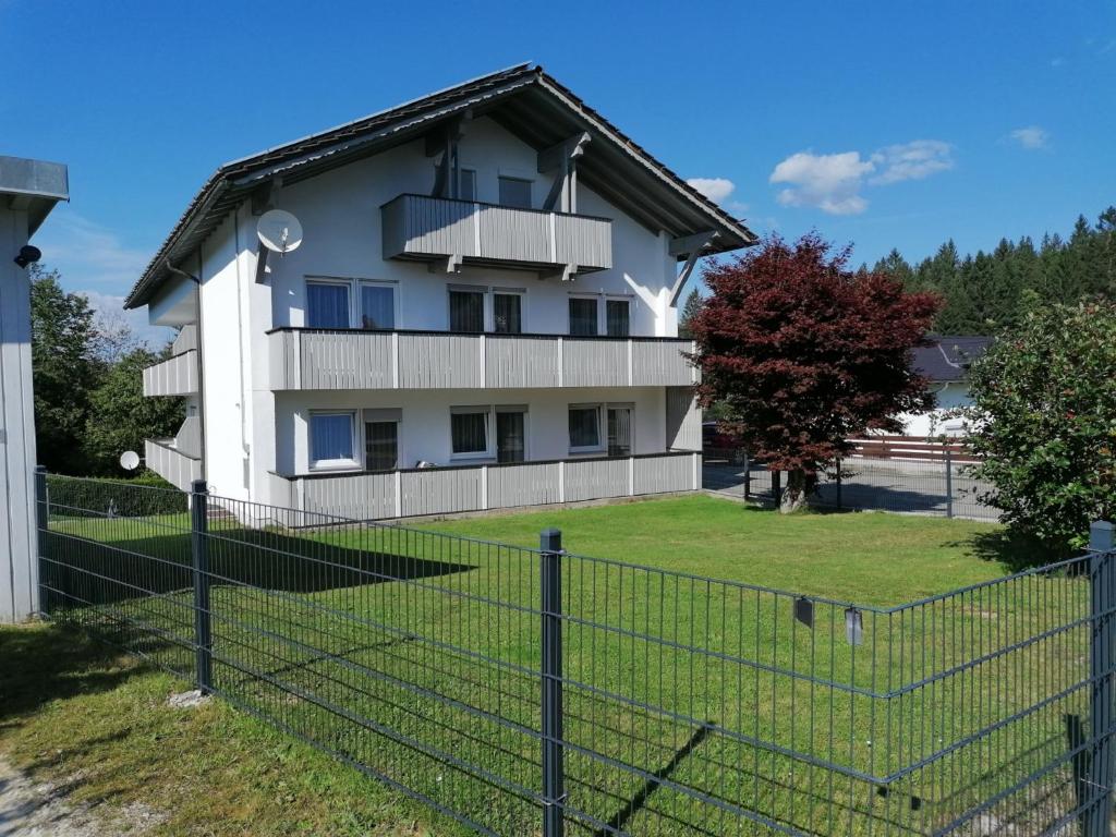 ein weißes Haus mit einem Zaun davor in der Unterkunft Ferienhaus Sonja in Lindberg
