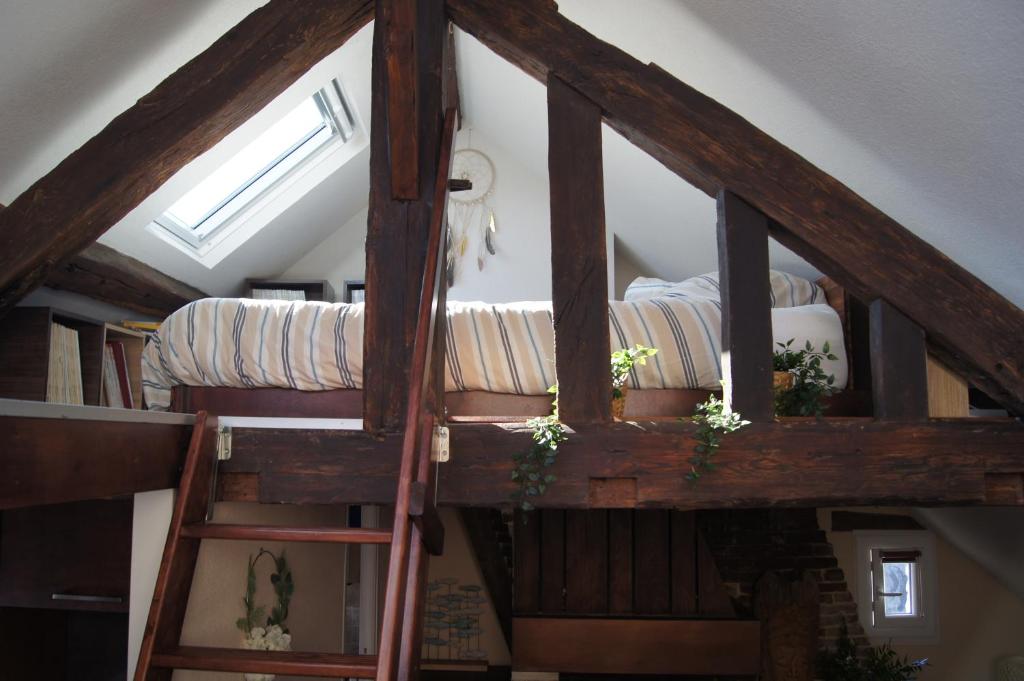 a loft bed in a room with a window at Le perchoir de St-Antoine in Honfleur