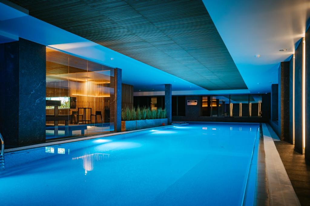 a swimming pool in the middle of a building at night at Hestia Hotel Haapsalu SPA in Haapsalu