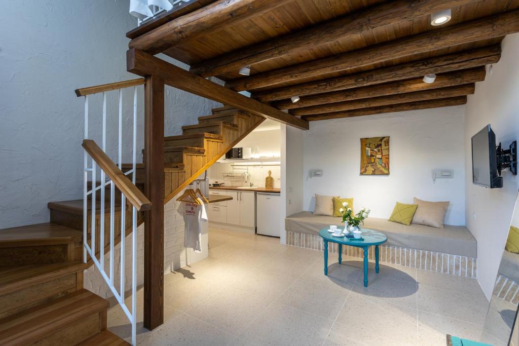 ein Wohnzimmer mit einer Treppe, einem Bett und einem Tisch in der Unterkunft Khujra Studios in Buxoro
