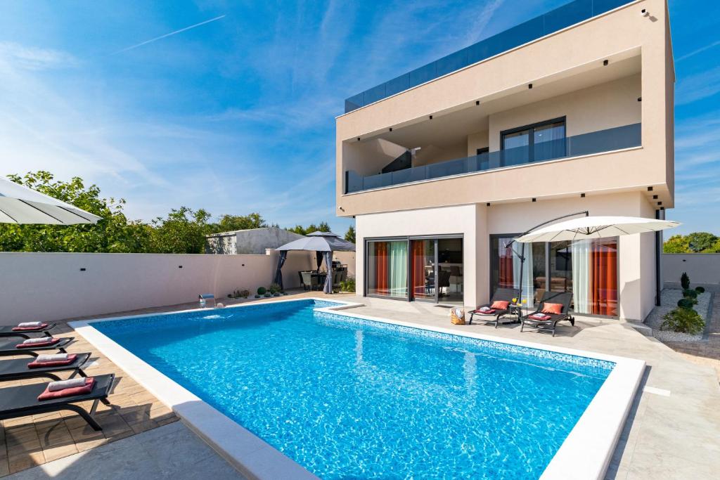 a swimming pool in the backyard of a house at Villa Sea View Mandriol in Barbariga