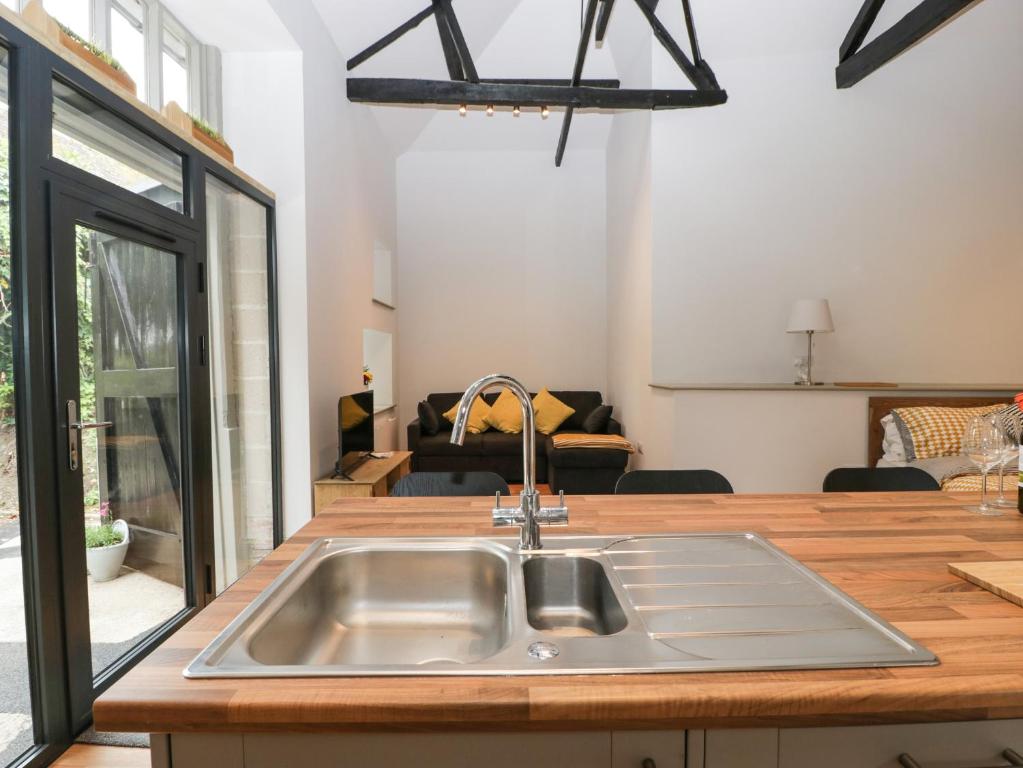 a kitchen with a sink and a living room at The Coach House in Horton
