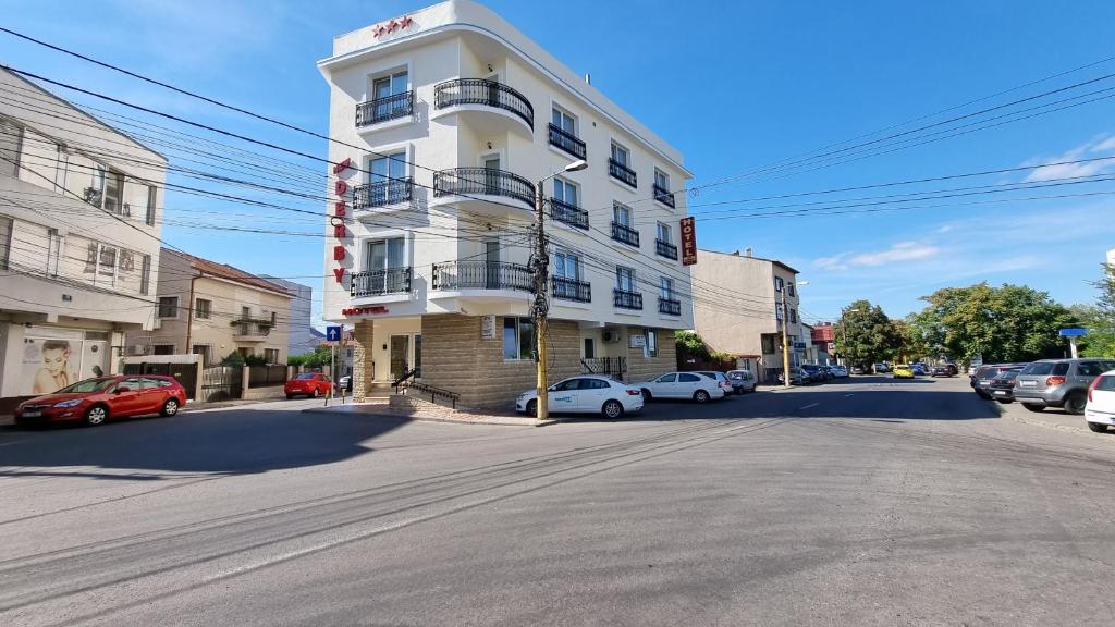 un edificio blanco al lado de una calle en Hotel New Derby, en Constanţa