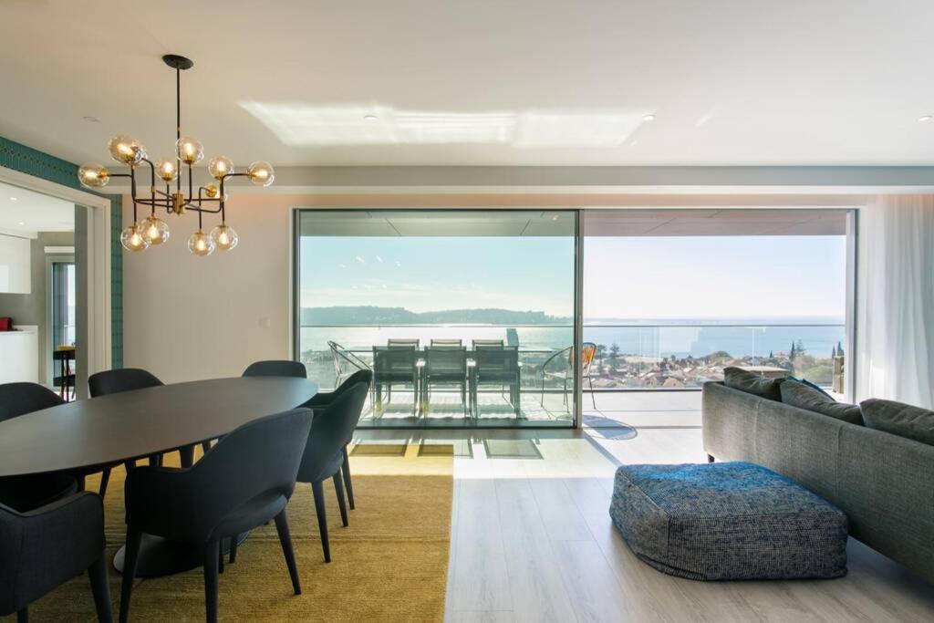 een woonkamer met een eettafel en uitzicht op de oceaan bij Luxury 4 bedr Flat w/ PANORAMIC Views & Pool!! in Algés