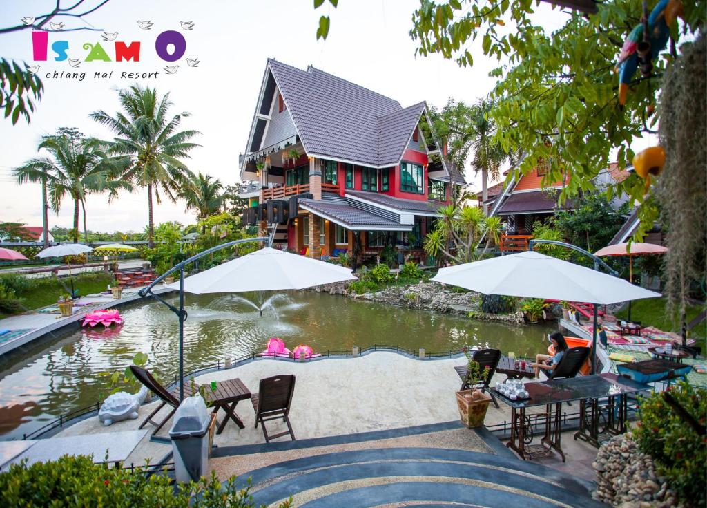 a house with a pond in front of a house at Is Am O Chiang Mai Resort in San Sai
