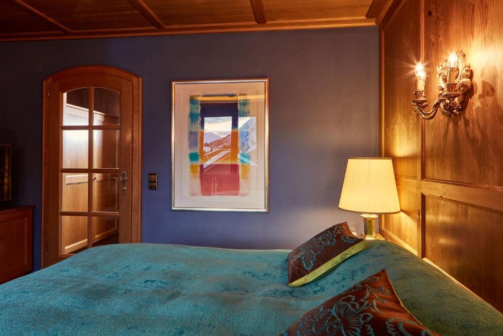 a blue bedroom with a bed and a lamp at Kristiania Lech in Lech am Arlberg