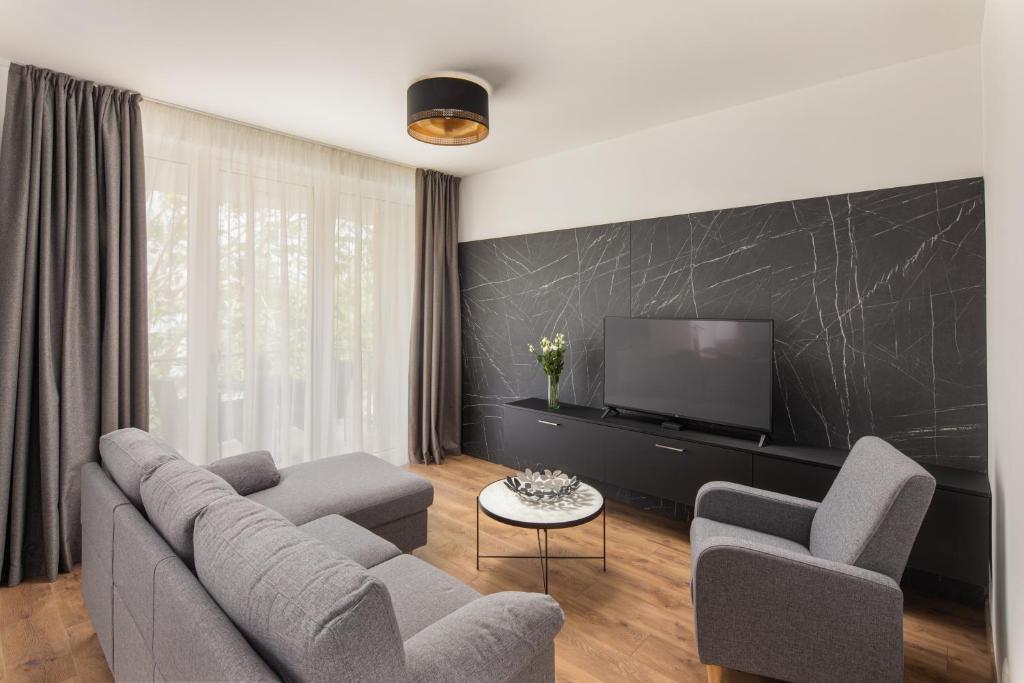 Televízia a/alebo spoločenská miestnosť v ubytovaní Hotel Carbona Spa Residence Apartmanok