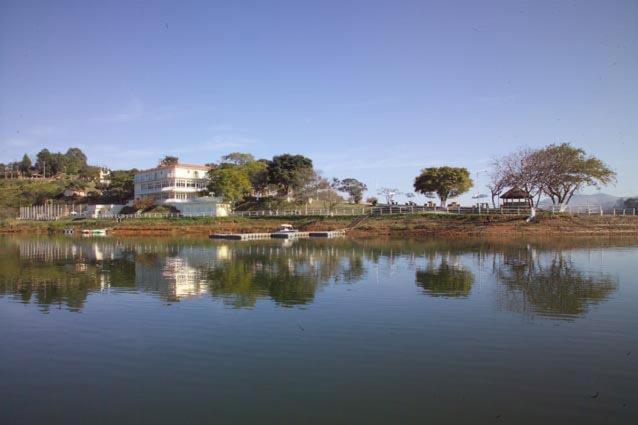 a large body of water with trees and a building at Pousada Marina Águas de Igaratá in Igaratá
