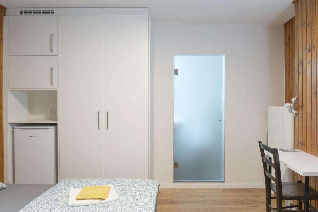 a dining room with a table and a refrigerator at Hôtel du Cheval-Blanc in La Chaux-de-Fonds