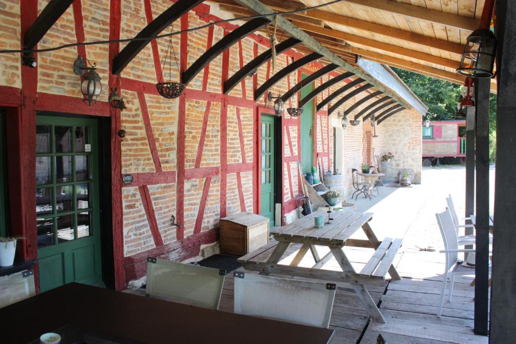 un patio al aire libre con mesa de madera y sillas en LE DOMAINE DU SENS en Frontenaud