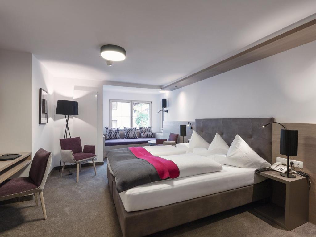 Postel nebo postele na pokoji v ubytování Quality Hosts Arlberg - Hotel Goldenes Kreuz B&B