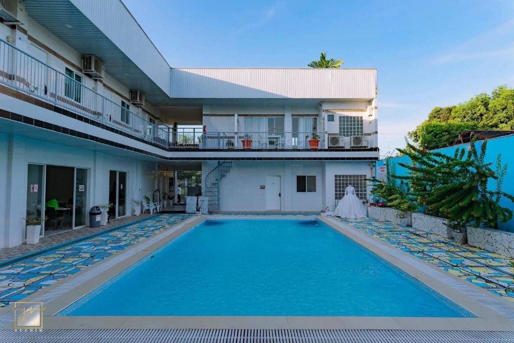 una piscina di fronte a un edificio di Sena Gladyz Suites a Panabo
