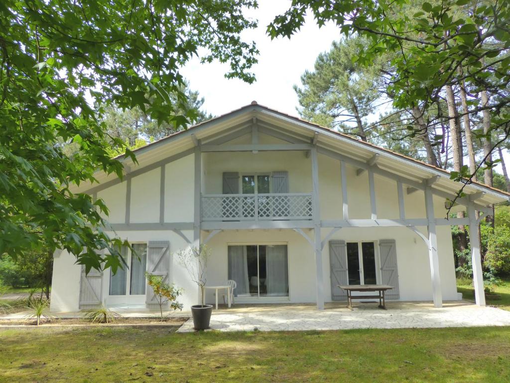 奧瑟戈爾的住宿－Villa Pinkmary Pour 10 Personnes，院子里的白色房子,长凳