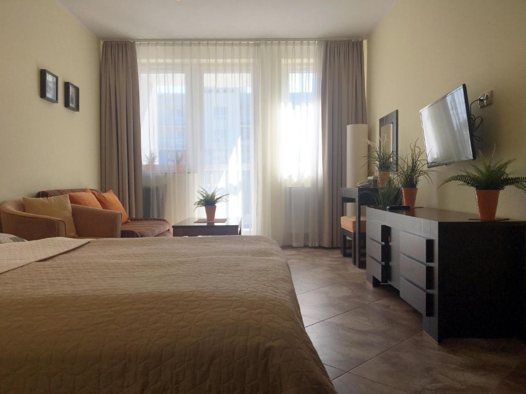 コウォブジェクにあるApartament prywatny w kompleksie hotelowym przy ul Kościuszki 16のベッドとリビングルームが備わるホテルルームです。