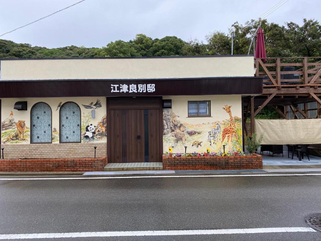 um edifício com um mural no lado da rua em 江津良別邸 em Shirahama