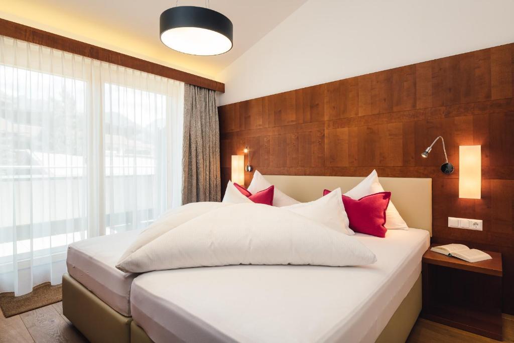 A bed or beds in a room at Schneeweiss lifestyle - Apartments - Living