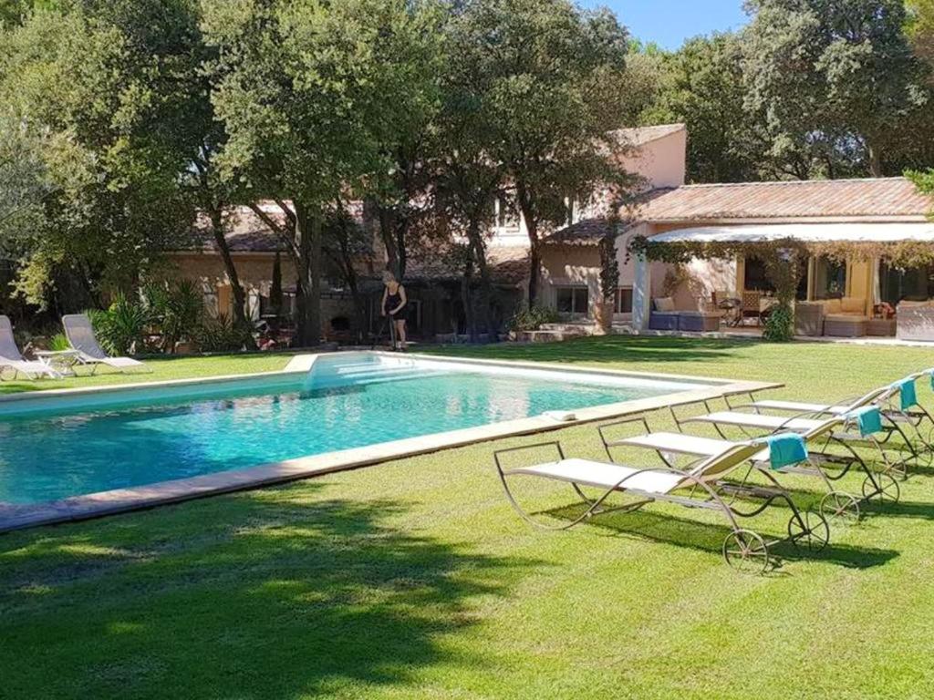 ein Pool mit zwei Gartenstühlen und ein Haus in der Unterkunft Villa raffinée à Orange avec piscine privée in Orange