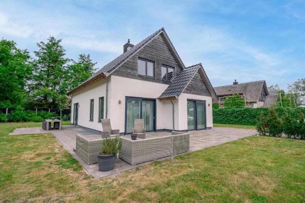 een groot wit huis met een patio in de tuin bij Hoogelandt 106F in De Koog