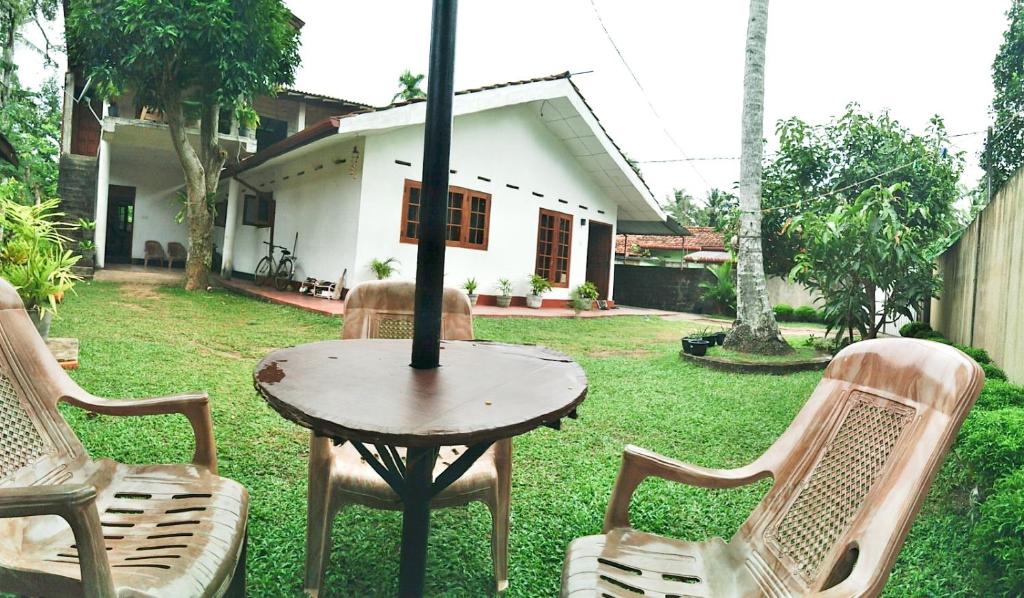Sanithu Homestay Galle في غالي: طاولة وكراسي في ساحة منزل