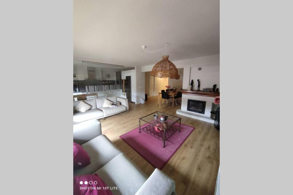 a living room with a couch and a fireplace at Un balcón sobre el Rio Sella in Ribadesella