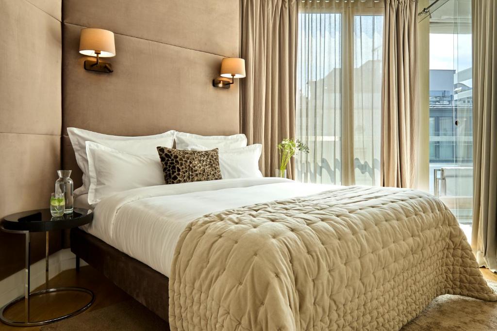a bedroom with a large bed and a large window at H15 Boutique Hotel, Warsaw, a Member of Design Hotels in Warsaw