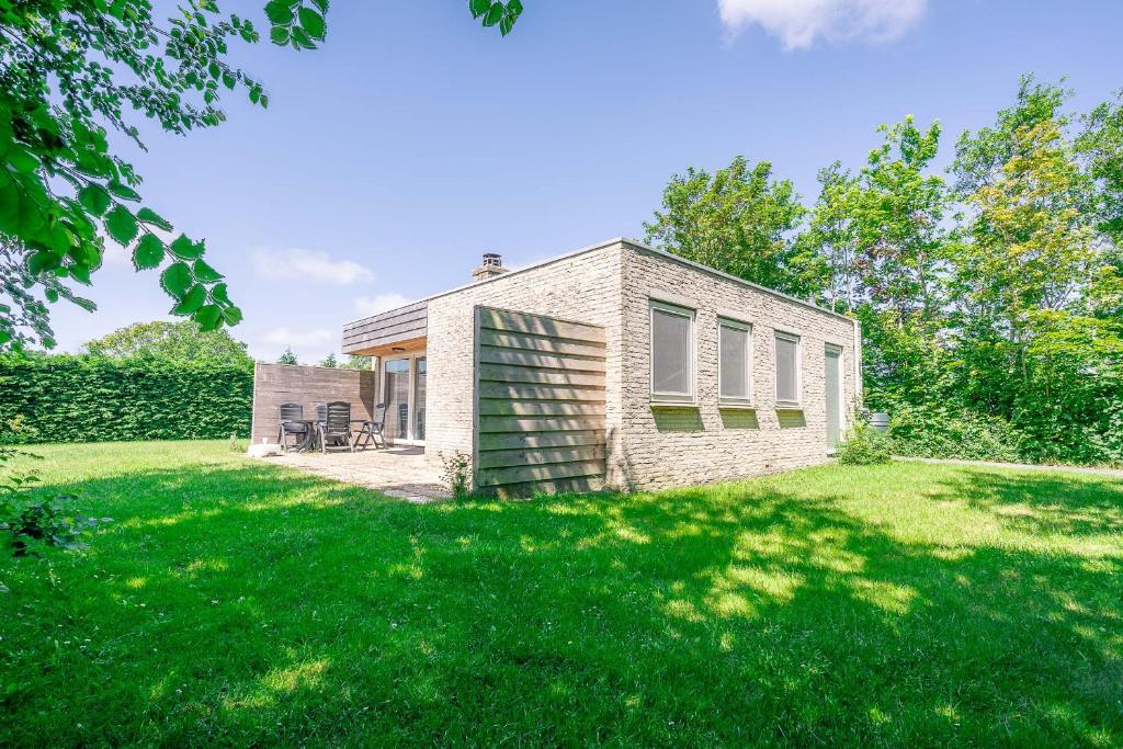 a brick house with a lawn in front of it at Hoogelandt 92 in De Koog