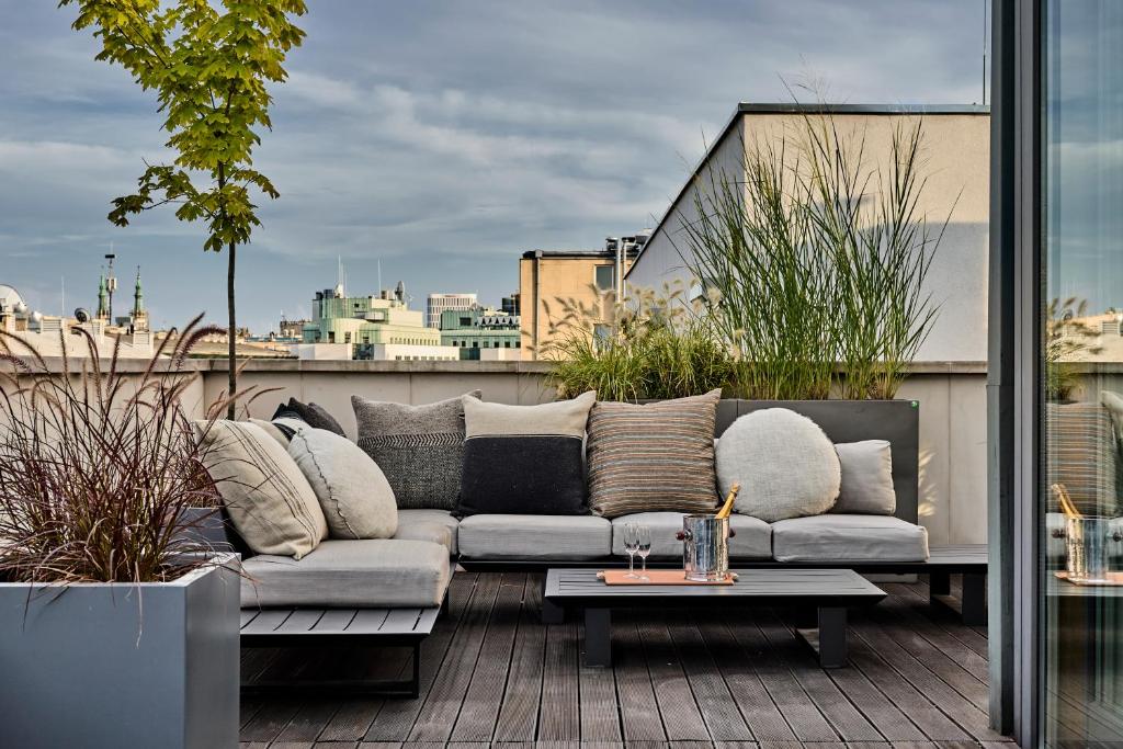a couch sitting on top of a balcony at H15 Boutique Hotel, Warsaw, a Member of Design Hotels in Warsaw