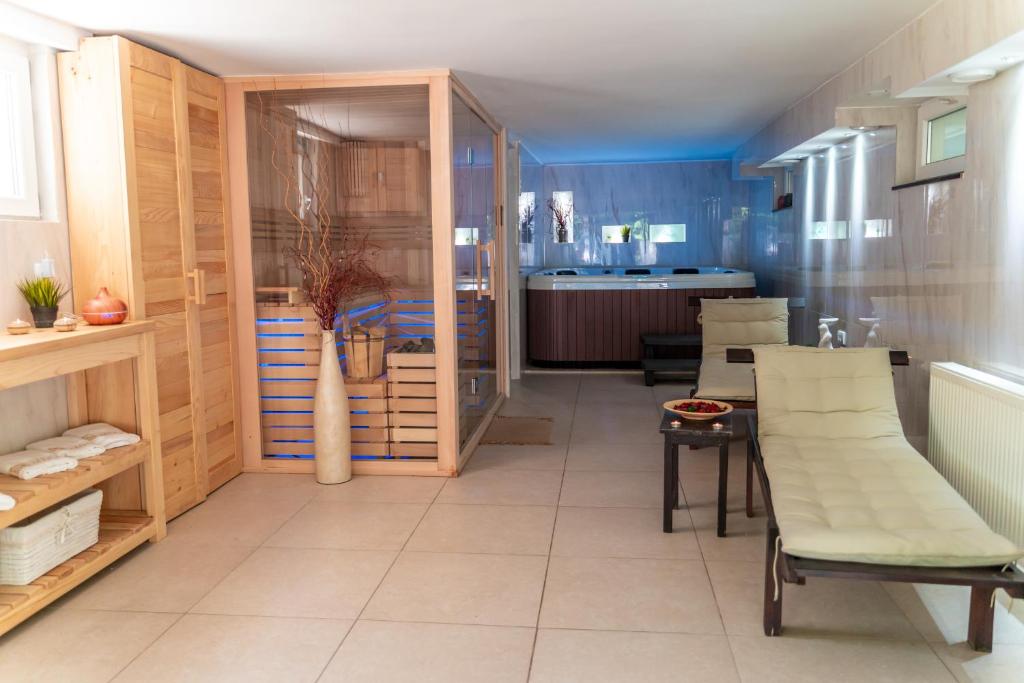 Vila Mila في أراندجيلوفاك: مطبخ بجدران خشبية وطاولة وكراسي