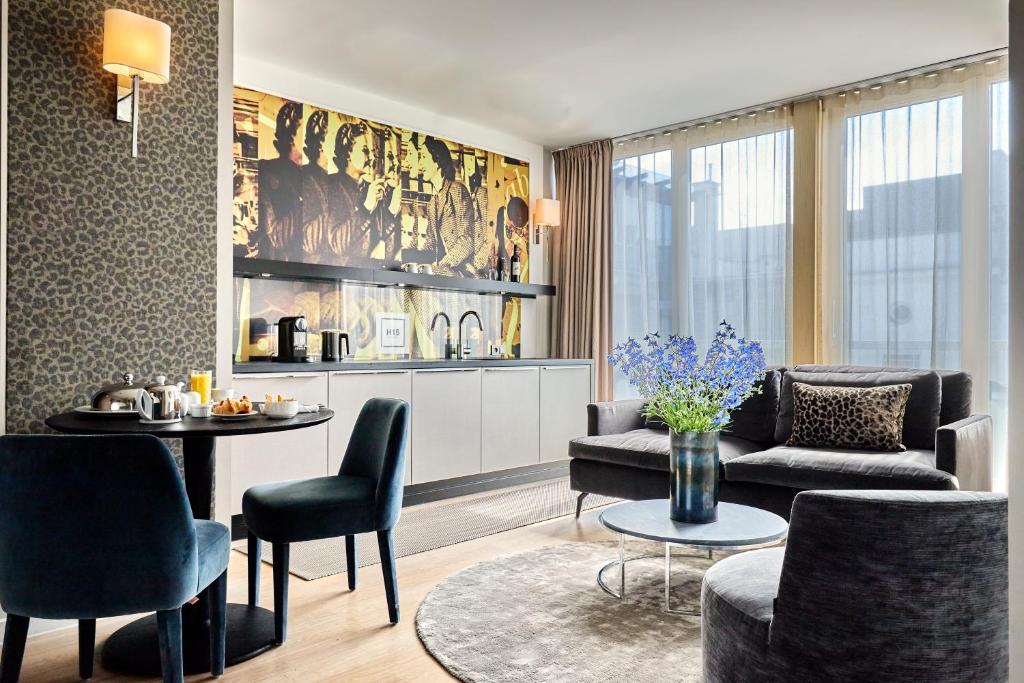 a living room with a couch and a table and chairs at H15 Boutique Hotel, Warsaw, a Member of Design Hotels in Warsaw