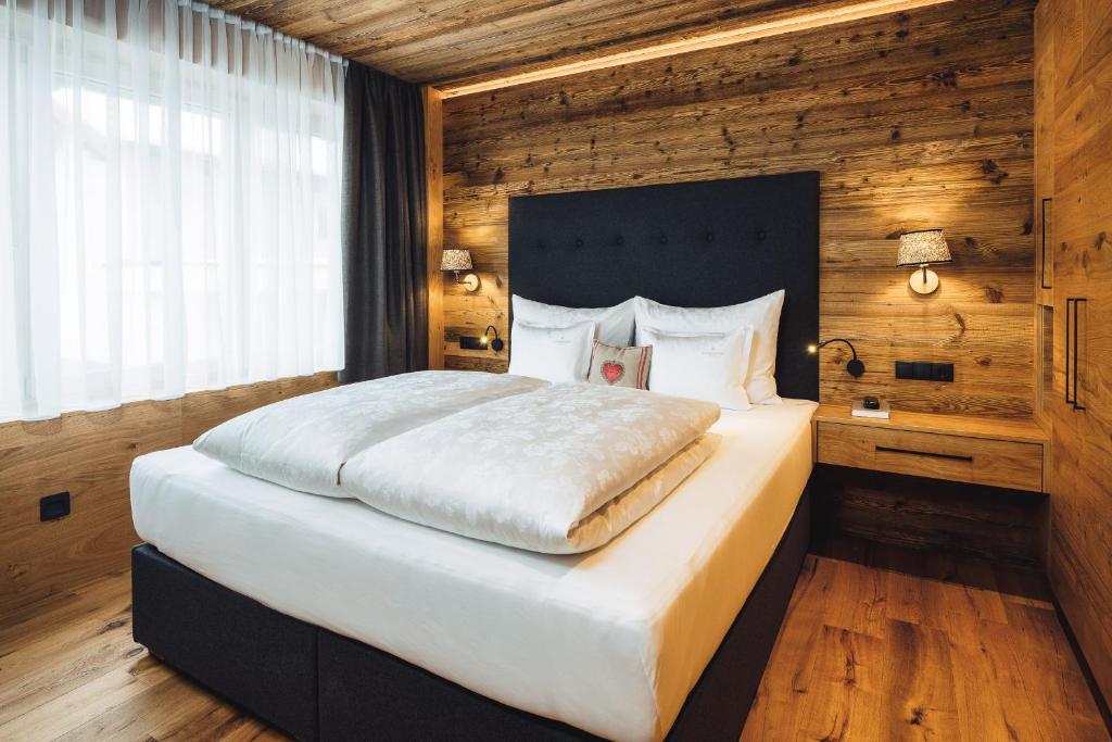 A bed or beds in a room at Schneeweiss lifestyle - Apartments - Living