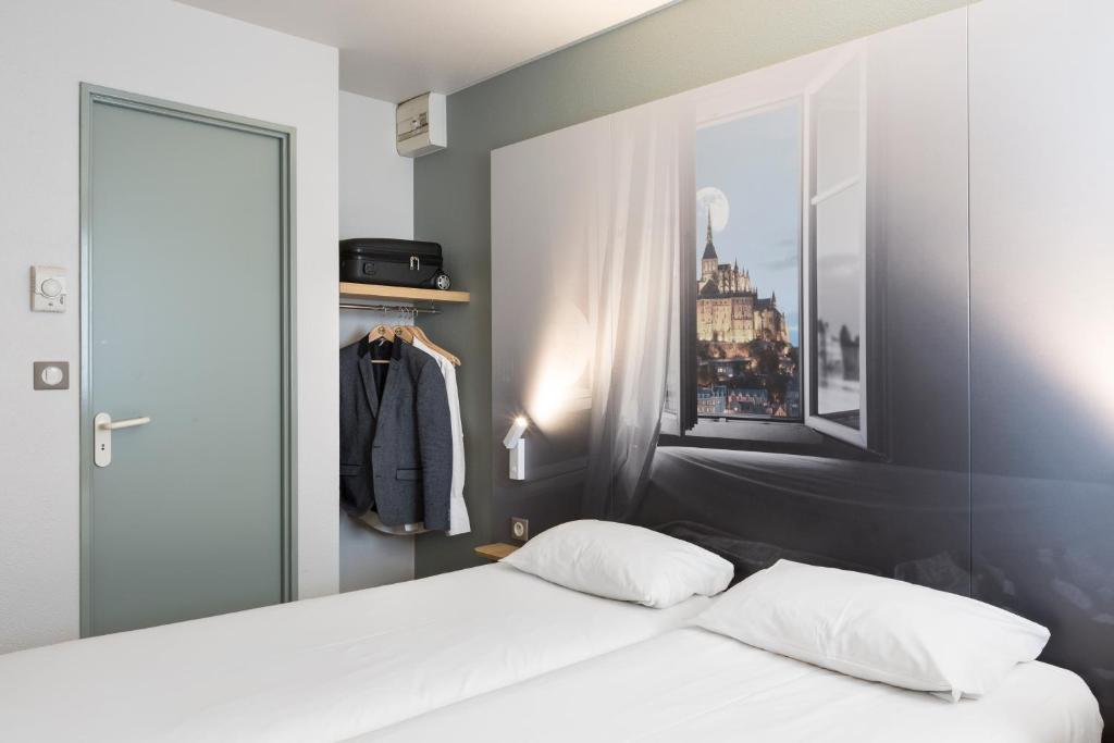 Postel nebo postele na pokoji v ubytování B&B HOTEL AVRANCHES Baie du Mont St-Michel