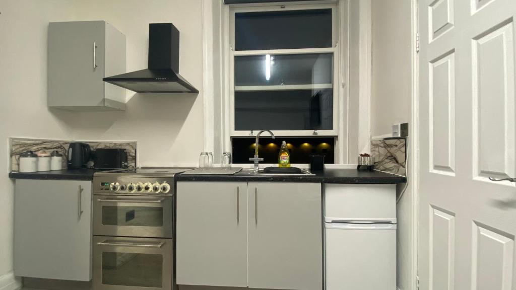 cocina blanca con fregadero y fogones en BVapartments-queengate 3, en Huddersfield