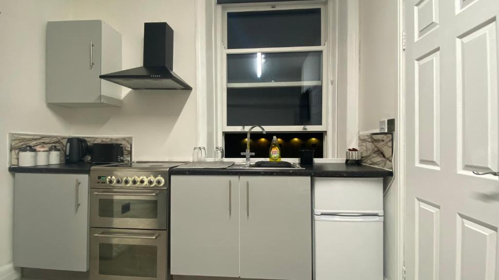 a white kitchen with a sink and a stove at BVapartments-queengate 3 in Huddersfield