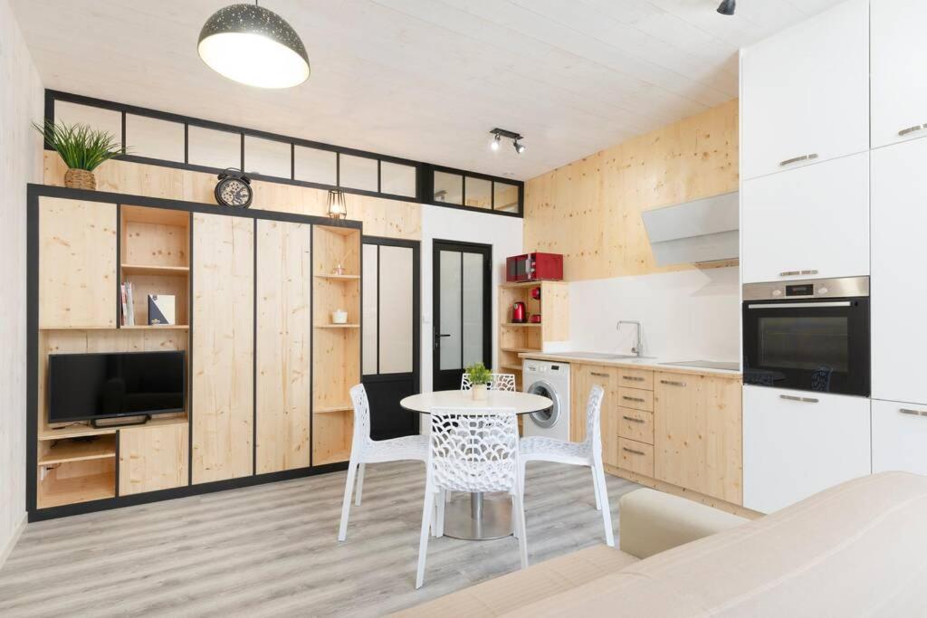 cocina con mesa y sillas en una habitación en Le Trésor des Soeurs Macarons, en Nancy