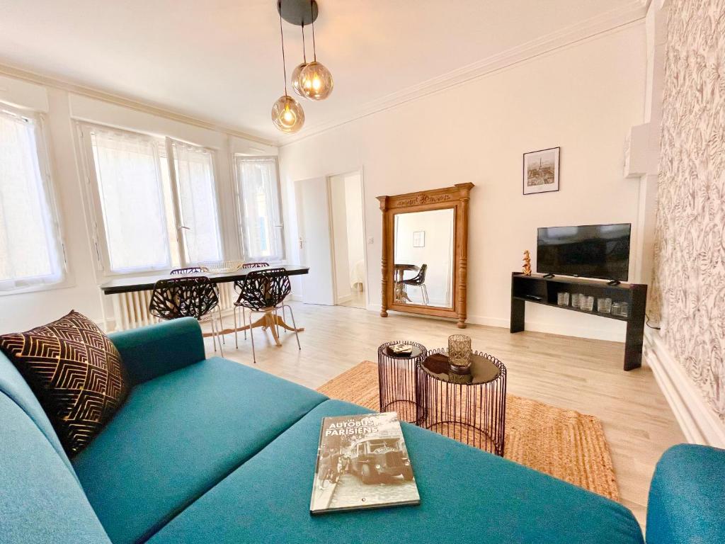 a living room with a blue couch and a piano at Le Mans - Au Calme - Stationnement Facile - Proche Centre Ville et Gare in Le Mans