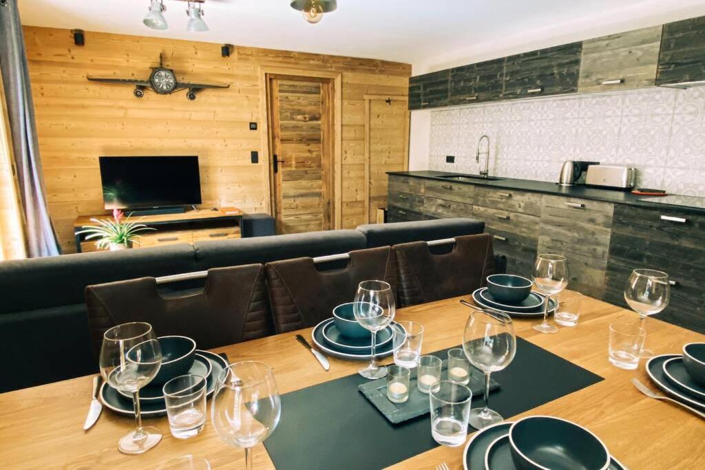 a dining room with a table with wine glasses on it at La pépite des Aiguilles in Les Houches