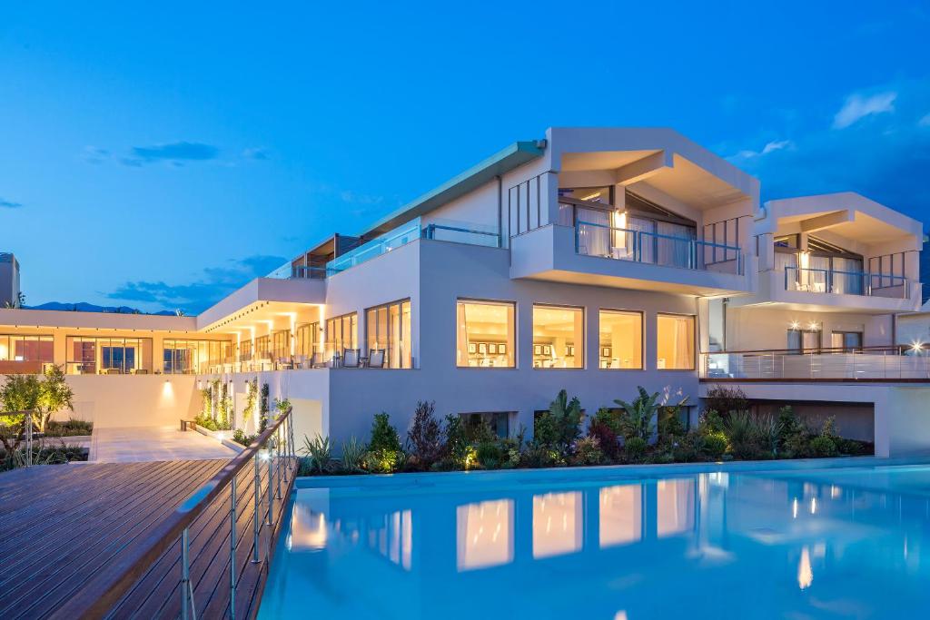 a villa with a swimming pool at night at Horizon Blu Boutique Hotel in Kalamata
